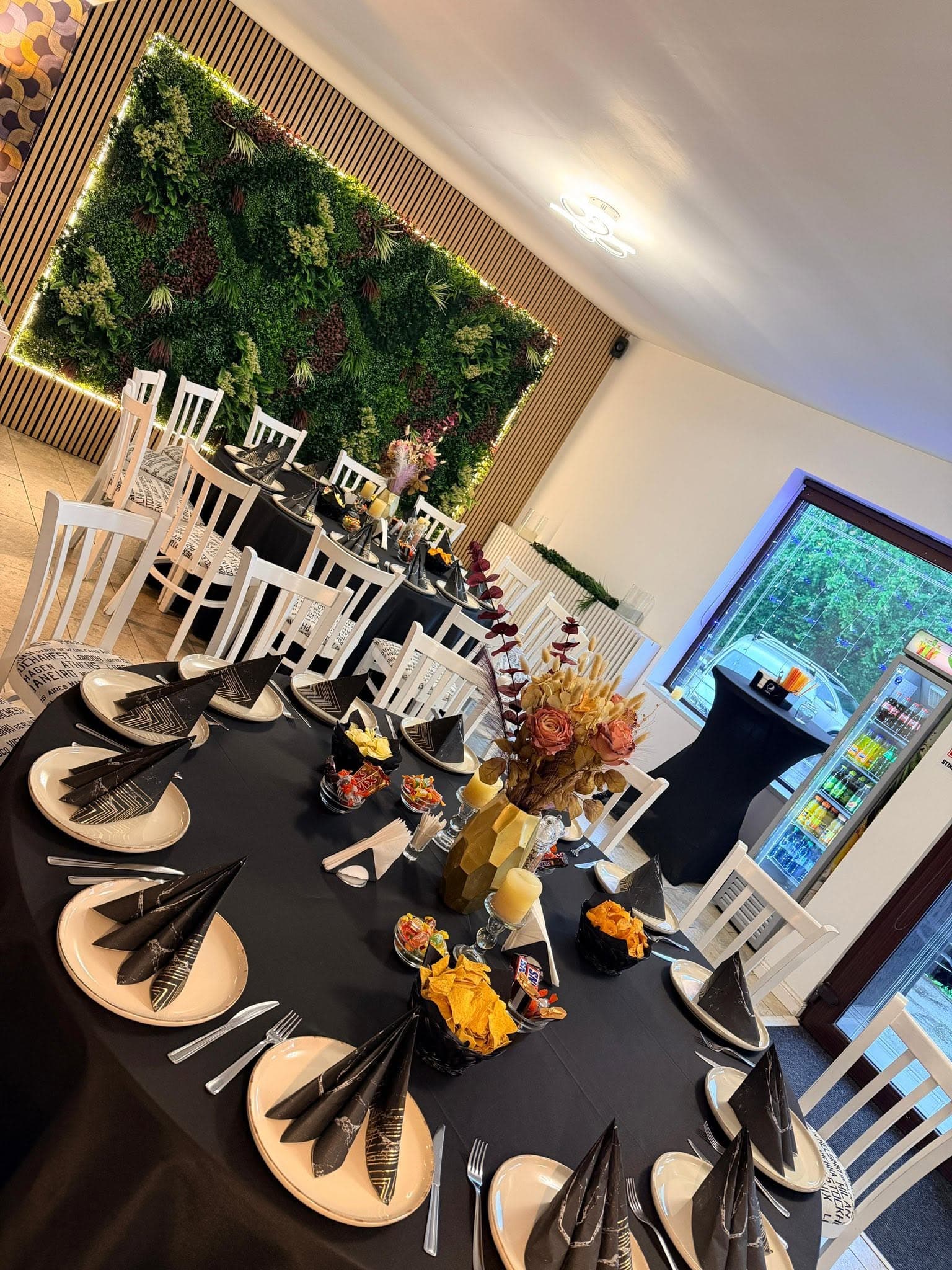 Interior elegant al sălii Private Society Events, cu perete verde și lumini calde
